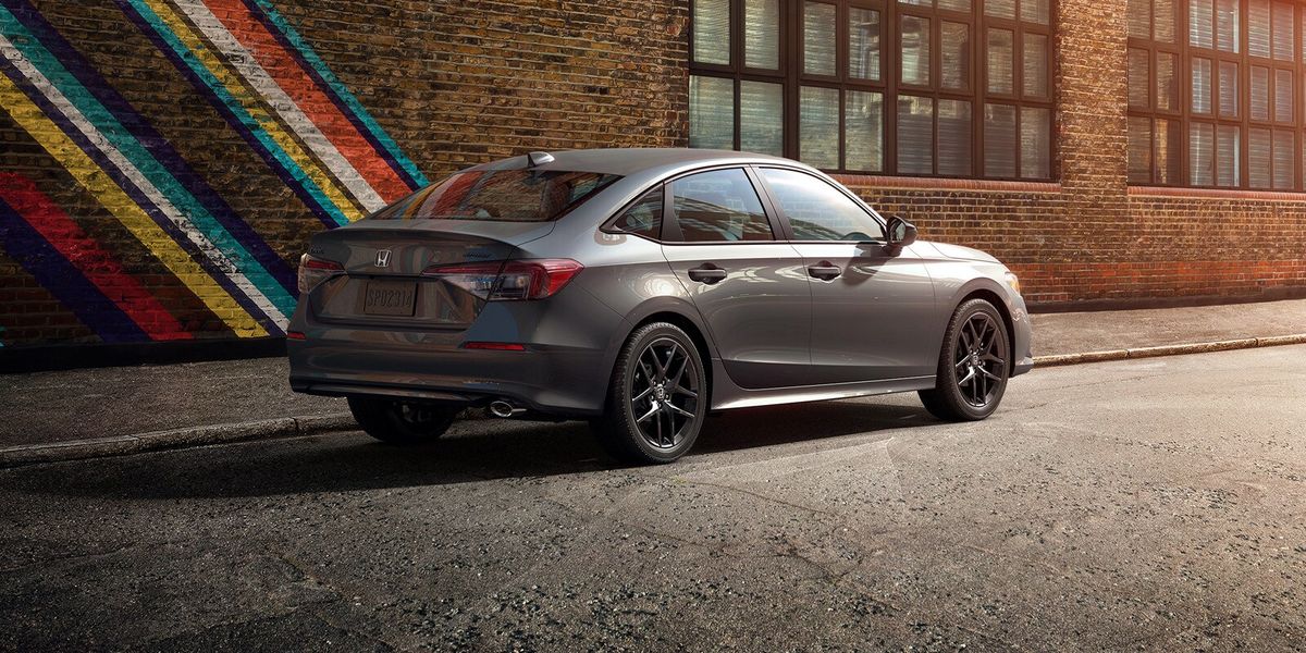 2026 Honda Civic Sedan Sport in Meteorite Gray Metallic rear three-quarter view parked on a city street (Compact Sedan)